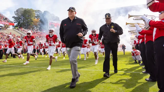 Todd Goebbel leads NC State onto the field for his first game as interim head coach following the program's firing of Dave Doeren, the winningest coach in program history. The Wolfpack defeated Cal, 31-10.