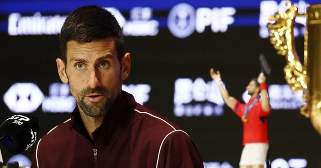 Novak Djokovic på presskonferens med en pokal i bakgrunden