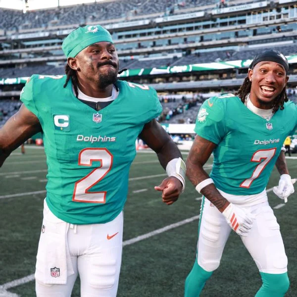 QB Malik Willis, left, and WR Caleb Douglas celebrate Miami's first win of the season Sunday.